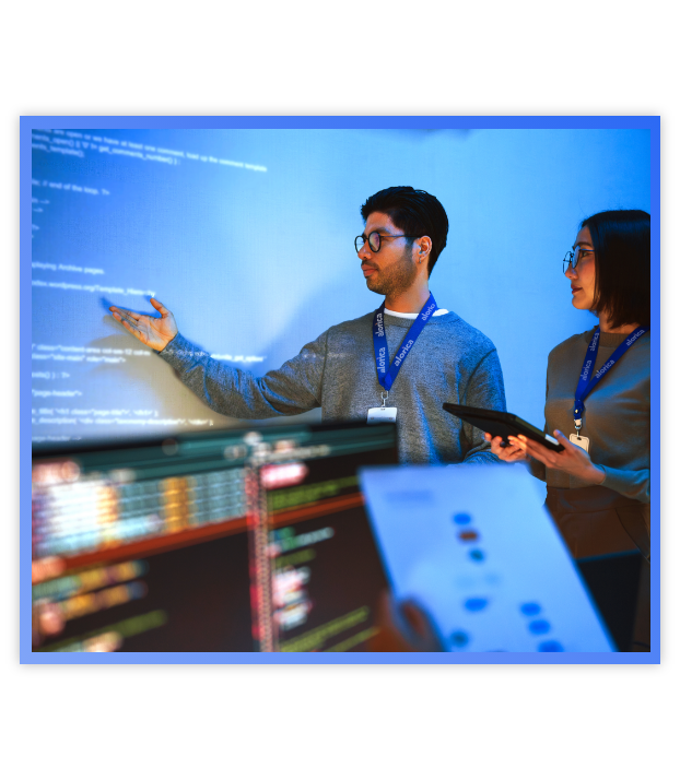 Man pointing at projector screen talking to a woman